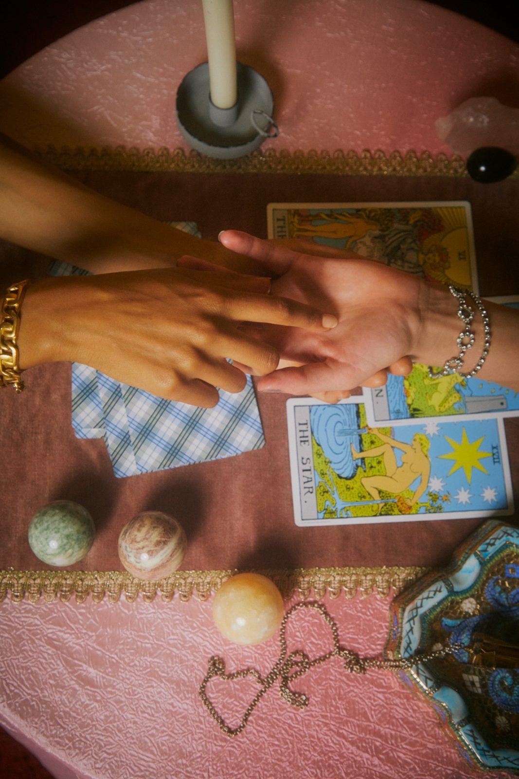 two hands meet across the table by candlelight
